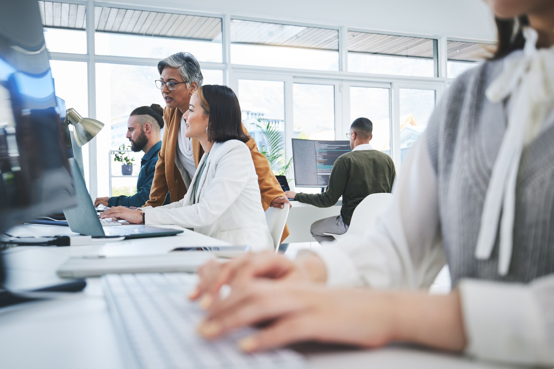 Programming, training and mentor with business people in office for cyber security, coding and developer. Software, technology and teamwork with employees and computer for data, research and coaching
